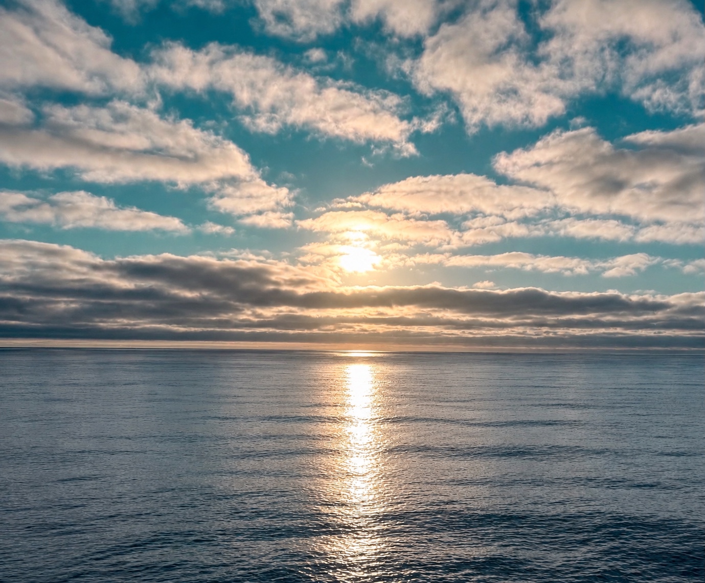 Sunlight breaking through clouds and reflecting across the ocean